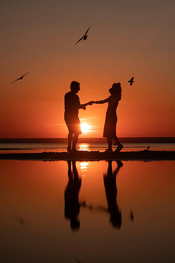 sunset, silhouette, couple dancing, beach, birds flying, water reflections, romantic scene, romantic couple, beach sunset, romantic beach, romantic dance