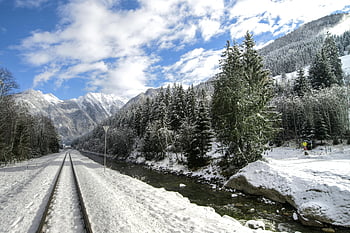 winter landscape, snow-covered trees, railway tracks, alpine mountains, pine trees, flowing river, blue sky, scenic winter, snow-covered alpine, winter scenery, train tracks
