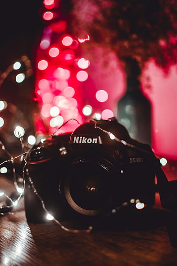 Nikon camera, colorful string lights, festive atmosphere, close-up photography, bokeh effect, camera equipment, string lights, photography gear, Nikon D5300, camera close-up, festive lighting
