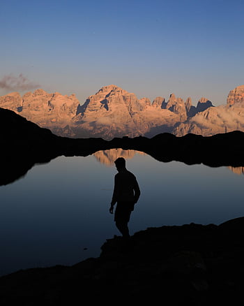 silhouette, man, lakeshore, dusk, calm lake, mountain reflections, serene, nature, outdoor, landscape, tranquility
