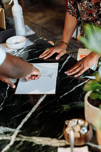 menu selection, menu pointing, styled store environment, black marble countertop, hands on menu, cafe setting, ergonomic menu design, cozy café atmosphere, restaurant customer interaction.