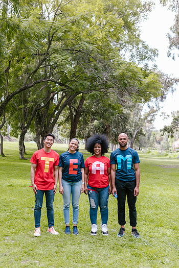 grupo de pessoas, grama verde, Camisas de equipe, Grupo diverso, adultos, de pé, parque, exterior, Espírito de equipe, roupa casual, cenário da natureza