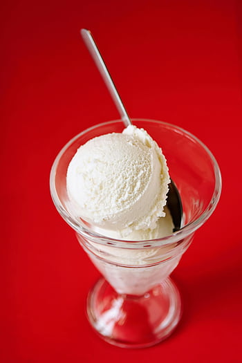 vanilla ice cream, glass dish, red background, ice cream scoop, spoon, dessert, vibrant red, creamy, sweet treat, cold dessert, glass bowl