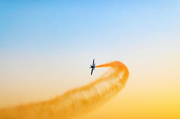 Black airplane, aerial stunt, vibrant sky, Dubai, UAE, airplane performance, sky show, aircraft, stunt flying, sunset sky, smoke trail