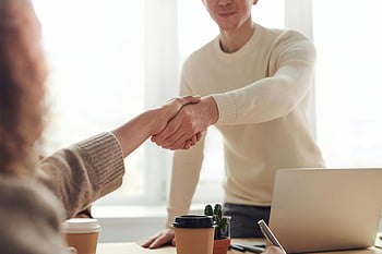 man and woman, shaking hands, modern office, coffee, professionals, close-up, table, business meeting, office setting, handshake, collaboration