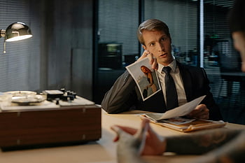 detective, suspect, interrogation, evidence photos, dimly lit room, questioning, male detective, interrogation room, crime scene photos, police investigation, suspect questioning