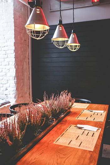 vintage restaurace, teplé jídelny, dřevěný stůl, Botanická výzdoba, průmyslová přívěsná světla, Útulná atmosféra, Vnitřní stolování, rustikální interiér, moderní osvětlení, interiér restaurace, Útulná restaurace