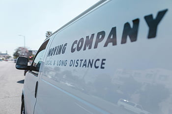 moving company, white van, close-up shot, sunny day, street scene, local long distance, vehicle sticker, company van, transportation, delivery service, commercial vehicle