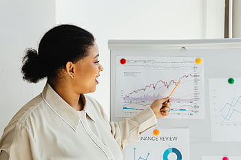 woman, explaining, charts, stock market, whiteboard, financial trends, presentation, business, data analysis, office, professional