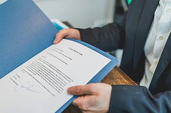 real estate contract, printed document, blue folder, agent review, client review, closeup photo, real estate agent, document review, real estate, contract review, blue document folder