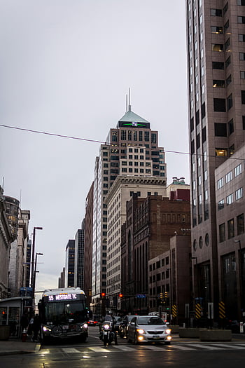 urban city, skyscrapers, traffic, bus, cloudy sky, vehicles on road, city scene, street view, downtown area, public transportation, cityscape