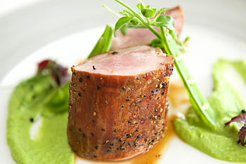 sliced pork tenderloin, herb garnish, green puree, white plate, meat dish, vegetables, pork, herbs, puree, plate, food photography
