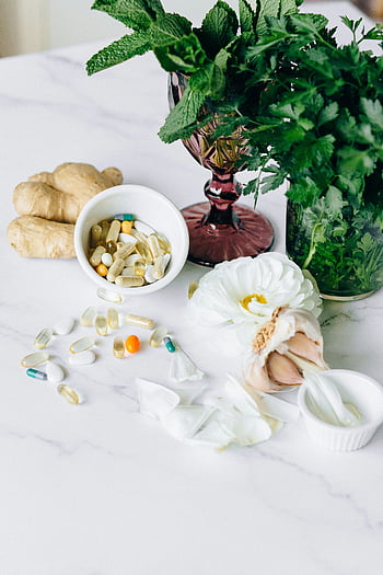 colocação plana, medicamentos alternativos, Plantas de ervas, Suplementos, saúde natural, superfície de mármore, ainda vida, alho, gengibre, pílulas, flores