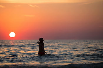Chlapec v oceánu, zlatá hodina, Silhouette Child, vlny oceánu, Závalný západ slunce, Klidná mořice, pláž při západu slunce, západ slunce oceánu, dítě hraje, plážové scény, přímou klid
