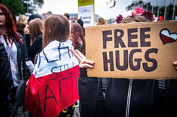 crowd, road, free hugs, outdoor rally, vibrant scene, protest sign, public gathering, street event, community event, social gathering, demonstration