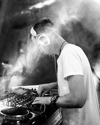 DJ, black and white, mixing music, dynamic smoke effects, lighting, controller, headphones, turntable, performance, nightclub, event