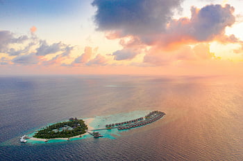 drone shot, beautiful resort, tropical island, luxury villas, turquoise waters, sunset, travel inspiration, vacation destination, idyllic paradise, aerial view, sunset beach