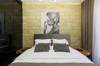 hotel bedroom, brick wall, contemporary bedroom, stylish artwork, soft lighting, comfortable bed, interior design, modern decor, wall painting, cozy room, hotel interior