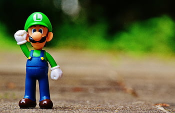 Luigi, plastic figure, shallow focus, close-up, videogame, outdoor pavement, fun, play, toy, figurine, character