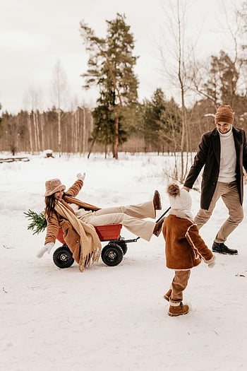 winter fun, snowy forest, family sled, man pulling woman, winter day, happy family, snow play, winter activities, snowy landscape, winter clothing, child playing