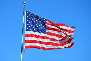 American flag, bright blue sky, waving flag, freedom symbol, patriotism, USA flag, majestic flag, red white blue, national symbol, outdoor scene, flagpole
