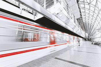 blurred motion, illuminated railroad station, city, high-speed train, sleek modern station, urban commuting, motion, train station, modern architecture, public transportation, city life