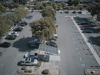 solar panel charging station, parking lot, cars, trees, aerial view, busy parking lot, solar panel, charging station, cars near trees, parking lot trees, solar energy