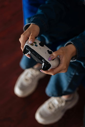 kabelloser Gamecontroller, Videospiel-Controller, Nahaufnahme Hände, Gaming-Engagement, Person, die spielt, Fokus auf Gaming, Videospiel spielen, Controller in den Händen, Gaming-Controller, Hände halten Controller, Spielaktivität