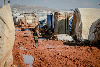 Sýrie, Idlib, uprchlický tábor, malé dítě, zablácený terén, stany, vyrovnání, odolnost, přežití, Humanitární krize, dítě chůze
