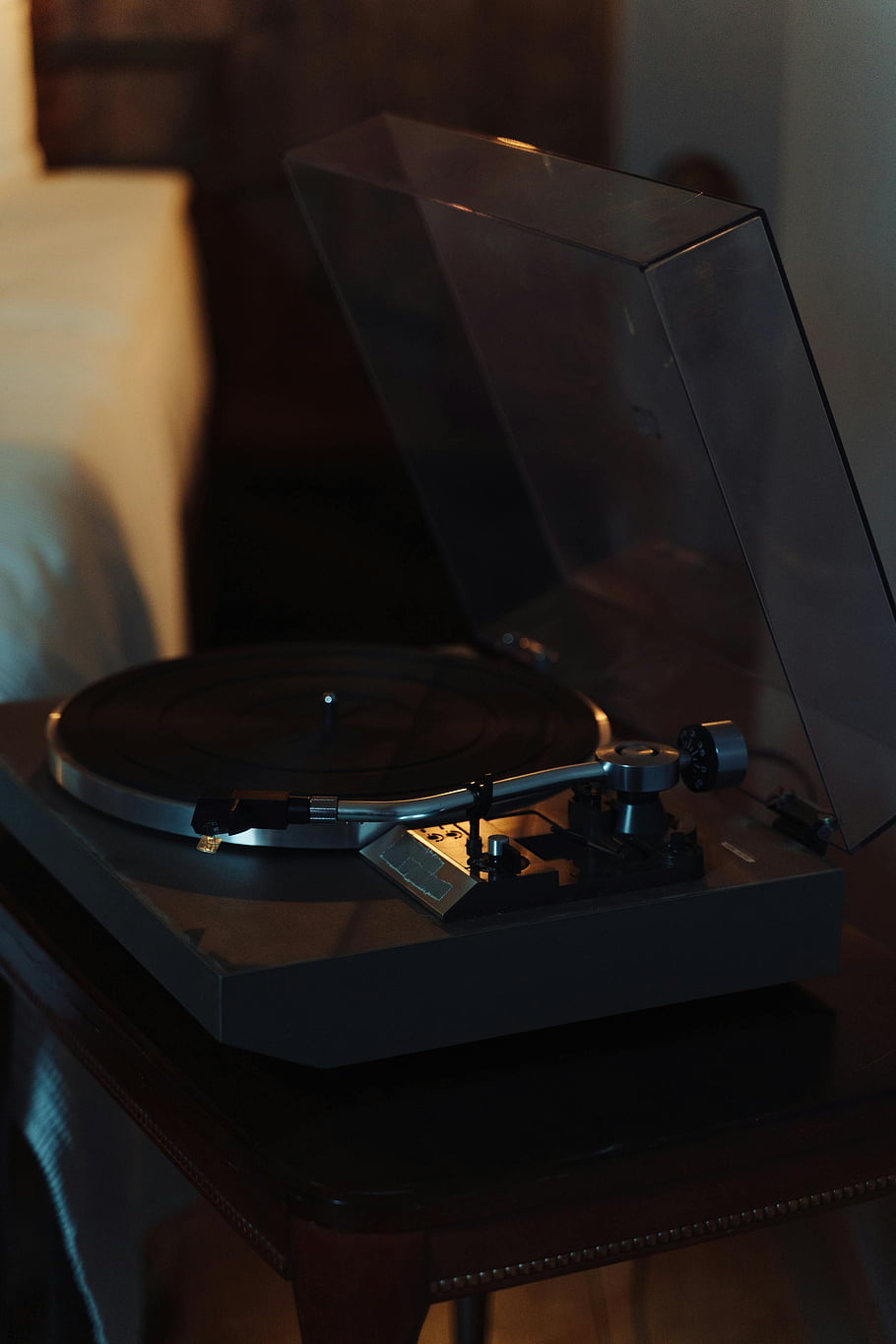 black vinyl record player, black table, classic turntable, vintage music technology, cozy indoor setting, vinyl record, turntable, indoor setting, music technology, black vinyl, black turntable