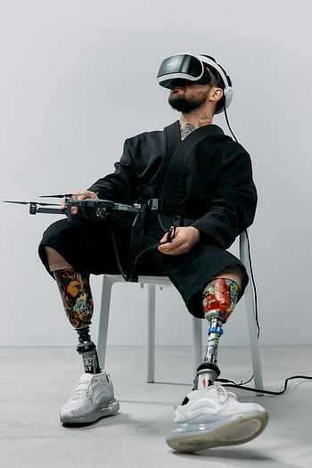 Muž s protetickými nohama, vr sluchátka, futuristické technologie, protetické nohy, virtuální realita, Muž používající VR, Adaptivní technologie, Technologie postižení, Protetické končetiny, Virtuální zkušenost, Muž s protetikou