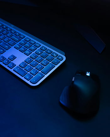 wireless keyboard, wireless mouse, sleek design, ambient lighting, tech enthusiasts, computer peripherals, modern setup, dark background, blue lighting, ergonomic design, wireless technology