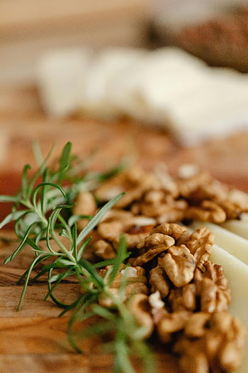 roasted nuts, herbs, wooden surface, walnuts, rosemary, charcuterie board, close-up, fresh walnuts, wooden board, food photography, culinary presentation
