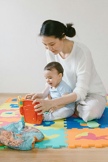 anya és a baba, Együtt játszani, színes puzzle szőnyeg, beltéri játék, játék interakció, családi kötés, gyermekfejlesztés, játékos pillanat, anyaság, baba játékok, beltéri tevékenységek