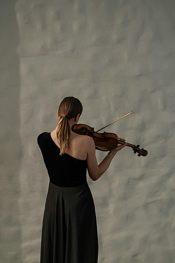 woman playing violin, back view, black dress, white wall, elegant woman, violinist, musical performance, indoor setting, artistic photography, classical music, ponytail