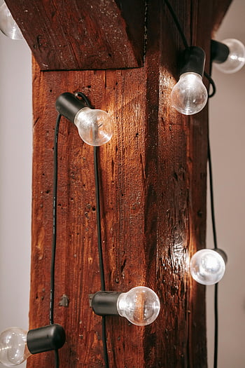 glowing lamps, wooden board, rustic wooden beam, hanging bulbs, cozy indoor decor, rustic decor, string lights, indoor lighting, warm lighting, home decor, rustic lighting
