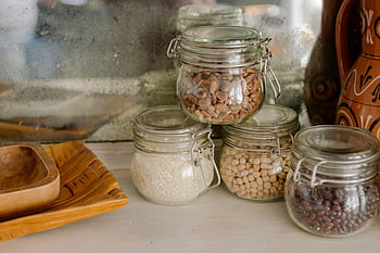 clear glass jars, white wooden table, kitchen scene, glass jars, chickpeas, rice, beans, wooden counter, elegant kitchen, food storage, pantry organization