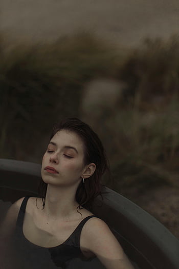 woman, black and white stripe tank top, serene portrait, relaxing moment, outdoor hot tub, dusk, outdoor relaxation, hot tub, dusk portrait, woman relaxing, outdoor scene