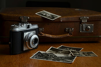 vinobraní fotoaparát, staré fotografie, kožený kufr, dřevěný stůl, Černá a šedá kamera, starožitný fotoaparát, vinobraní fotografie, kožené pouzdro, dřevěný povrch, retro fotoaparát