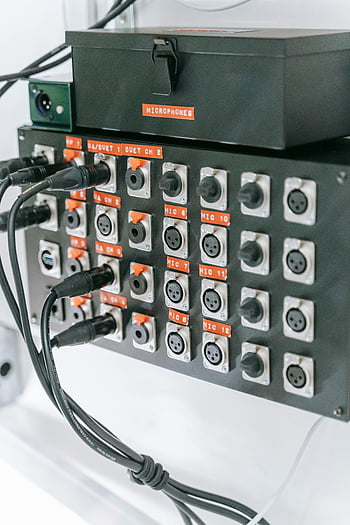 audio equipment, XLR inputs, microphone setup, professional audio, cables plugged in, audio panel, multiple inputs, audio tuner, audio connections, audio interface, audio gear