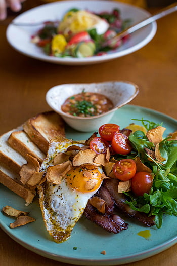breakfast plate, bacon, sunny side up egg, fresh veggies, tomatoes, toast, salad, breakfast dish, brunch, food photography, meal presentation
