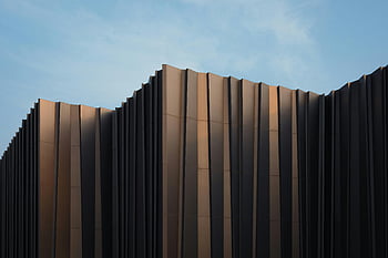 hnědá výšková budova, Elegantní moderní budova, Unikátní design, jasné modré nebe, stavební fasáda, současná architektura, městské panorama, architektonický design, moderní struktura, panoráma města, Výšková architektura