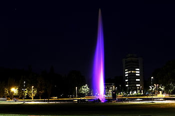 紫色のライトが付いた噴水、 活気のある噴水、 照らされた噴水、 夜の街並み、 現代の都市、 紫色のライト、 夜景、 都市の噴水、 都市噴水、 屋外の噴水、 夜の照明