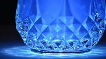 blue reflection, close-up, crystal glass, blue illuminated, geometric patterns, reflections, intricate design, glassware, blue light, detailed texture, glass object