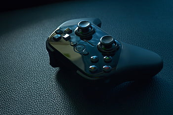 black wireless game controller, black leather, modern gaming controller, dark textured surface, close-up, wireless controller, game controller, black controller, dark surface, gaming accessory, textured leather