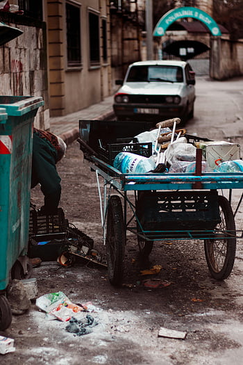 garbage collection, street scene, urban waste, trash cart, litter, pavement, waste issues, person collecting garbage, urban environment, waste management, street cleaner