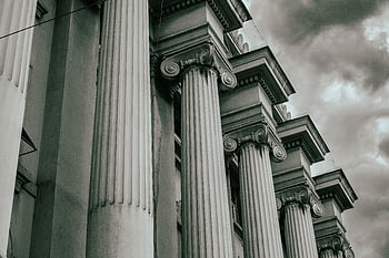 Classic Marble Columns, Greco-Roman columns, grayscale image, cloudy sky, dramatic photo, architectural details, historical architecture, ancient columns, classical architecture, black and white photography, monumental columns