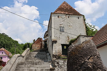 opevněný kostel, Șoala, 15. století, žebrový trezor, farní dům, lemující věž, třípodlažní bašta, baptisterium, kamenné schody, bílé stěny, modrá obloha