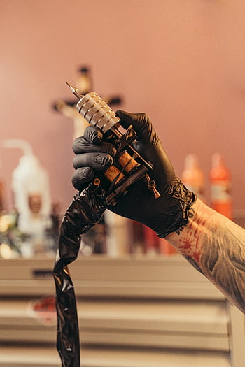 tetování, černé rukavice, tetování stroj, studio, rozmazané pozadí, Profesionální tetování, tetovací vybavení, tetovací studio, tetovací proces, Tattoo Artist Hand