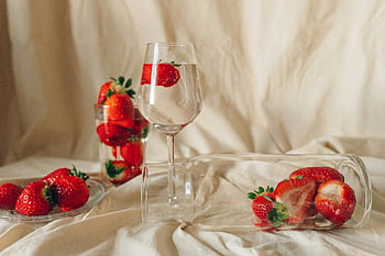 red strawberries, clear wine glass, elegant arrangement, still life composition, strawberries in wine, glass jars, fruit photography, food art, minimalist style, natural light, aesthetic still life